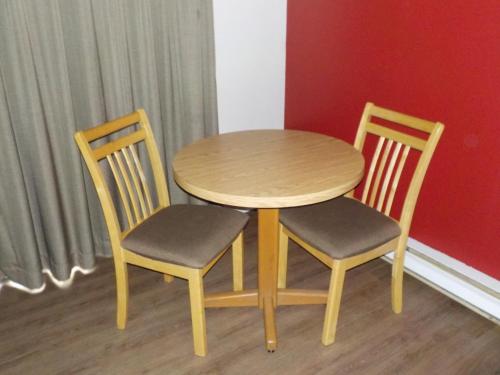 a wooden table and chairs in a room at Econolodge Vernon in Vernon