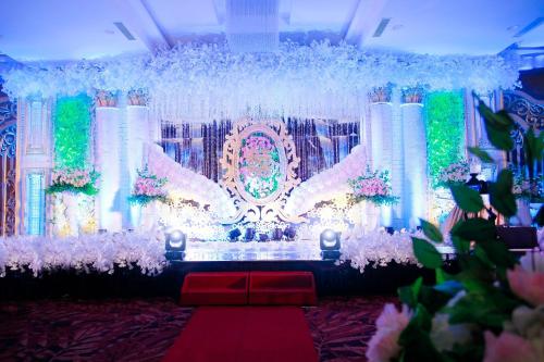 a room with a stage with flowers and lights at Platinum Hotel & Convention Hall Balikpapan in Balikpapan