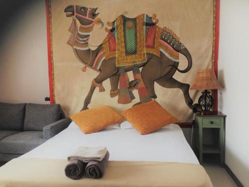 Résidence Marina Beach في نومْيا: غرفة نوم بسرير مع لوحة على فيل