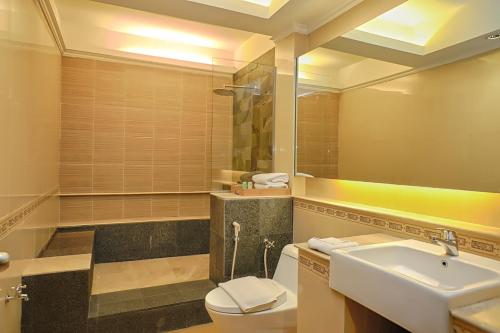 y baño con lavabo, aseo y espejo. en Bali World Hotel, en Bandung