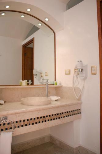 un bagno con un lavandino e un grande specchio di Hotel Malinalli a Huamantla