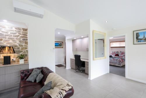 a living room with a couch and a bedroom at Armidale Cottage - House 2 in Armidale