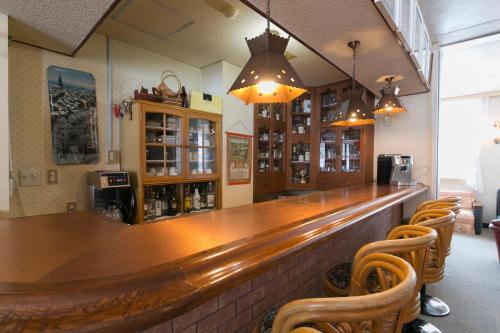 a bar with a wooden counter and some chairs at Rosenheim Hakuba in Hakuba