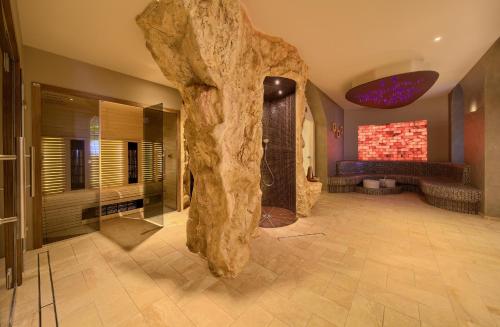 a bathroom with a large stone pillar in the middle of the room at Floating Holiday Home in Punat