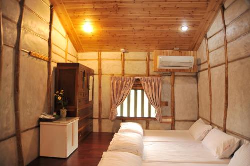 a small room with a bed and a window at Fengnan Tianzhuang Homestay in Fuli
