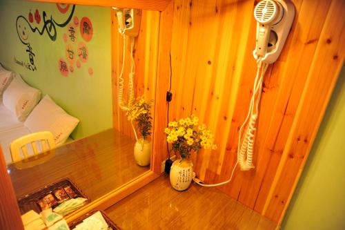 a room with two vases of flowers and a fan at Fengnan Tianzhuang Homestay in Fuli