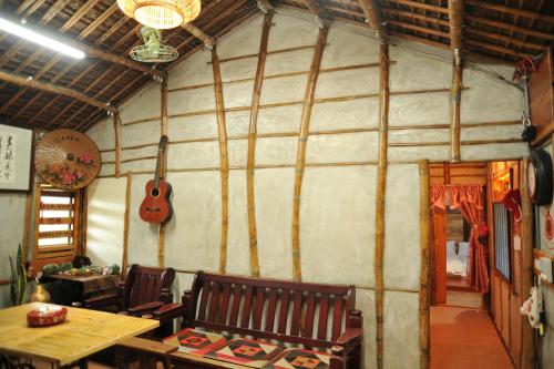 a room with a table and a guitar on the wall at Fengnan Tianzhuang Homestay in Fuli