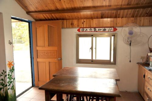 a kitchen with a wooden table and a window at Fengnan Tianzhuang Homestay in Fuli