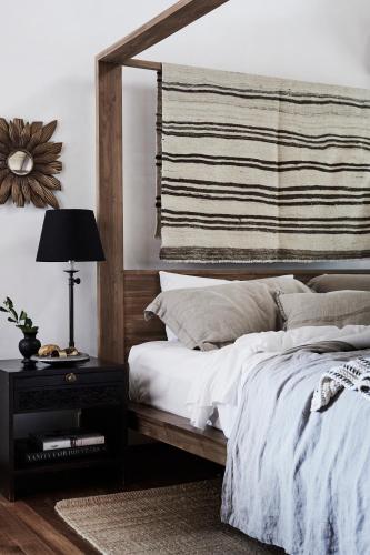 a bedroom with a bed with a wooden headboard at The Villas of Byron in Byron Bay