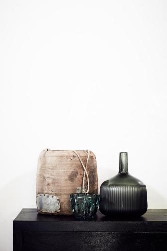 a table with a container and a vase on it at The Villas of Byron in Byron Bay