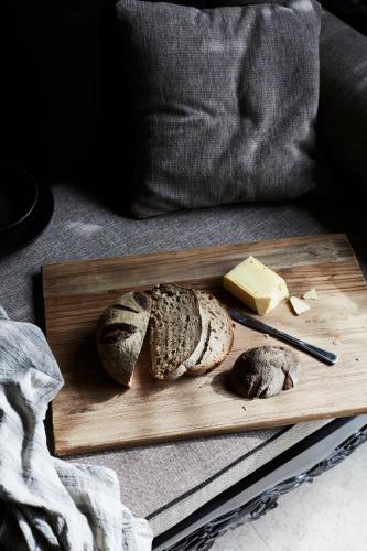 a cutting board with bread and cheese on a couch at The Villas of Byron in Byron Bay