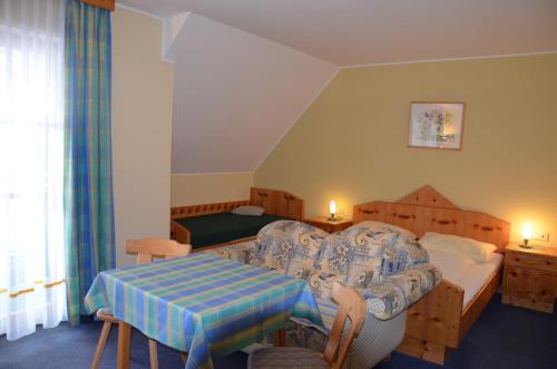 ein Schlafzimmer mit einem Bett und einem Tisch in einem Zimmer in der Unterkunft Wildwiesenhof in Miesenbach