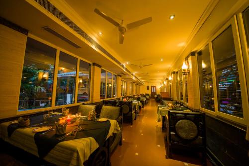a restaurant with beds and tables in a room at The Renai Cochin in Cochin