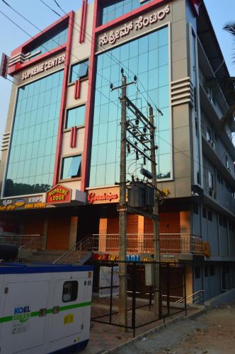 a building with a pole in front of it at SUPREME LODGe in Dharmastala