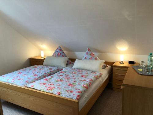 ein Schlafzimmer mit einem großen Bett mit zwei Nachttischen in der Unterkunft Gästehaus Katharina in Müllenbach