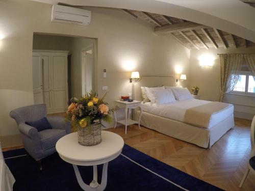 - une chambre avec un lit et une table ornée d'un vase de fleurs dans l'établissement Palazzo della Stufa Residenza D'Epoca, à Florence