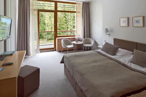 a hotel room with a bed and a window at Špik Alpine Resort in Kranjska Gora