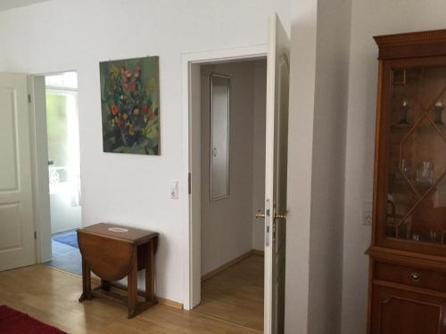 a hallway with a table and a painting on the wall at Ferienwohnung Villa Josephine in Badenweiler