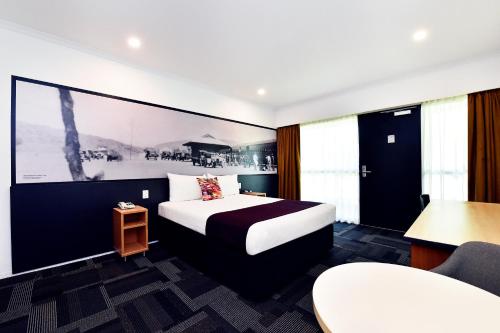 una stanza d'albergo con un letto e un tavolo di Mercure Alice Springs Resort a Alice Springs