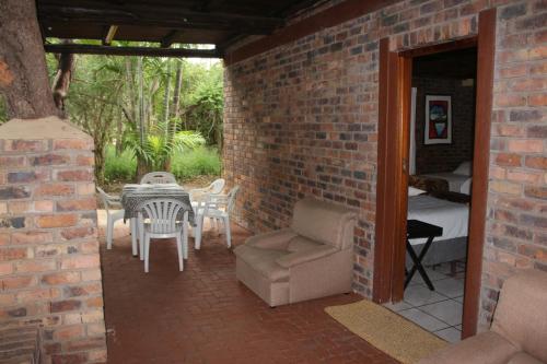 a brick house with a patio with a table and chairs at Jabula Kruger Safari Lodge in Marloth Park