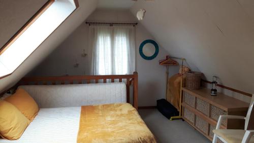 Schlafzimmer im Dachgeschoss mit einem Bett und einem Fenster in der Unterkunft Le Mouton Blanc in Couloisy