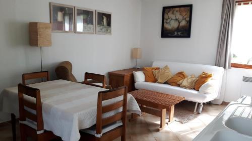 ein Wohnzimmer mit einem Sofa und einem Tisch in der Unterkunft Le Mouton Blanc in Couloisy