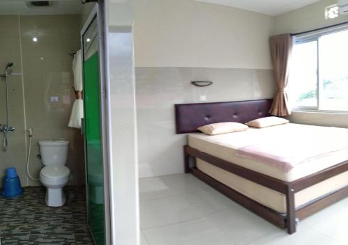 a small bedroom with a bed and a toilet at Tirta Kencana Baturraden in Baturaden