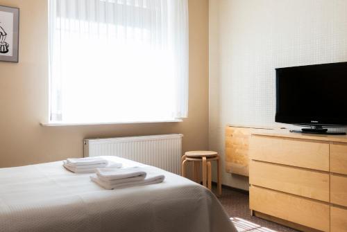 een slaapkamer met een bed en een tv op een dressoir bij Villa Stratus in Gdańsk