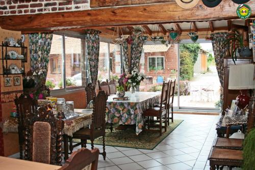 a dining room with a table and chairs and a window at La ferme de la vallée in Auchy-au-Bois