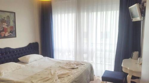 a bedroom with a bed and a sink and a window at Urkmez Hotel in Selcuk