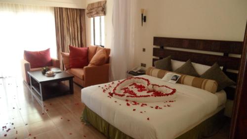 a bedroom with a bed with a red flower arrangement on it at Lake Bogoria Spa Resort in Marigat