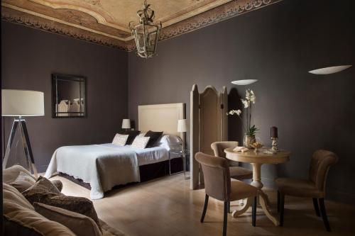 um quarto com uma cama, uma mesa e cadeiras em Palazzo Branchi em Florença