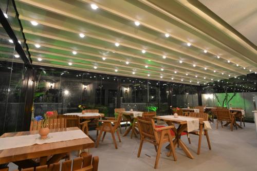 a restaurant with wooden tables and chairs and lights at Dalyan Risus Suite in Çeşme