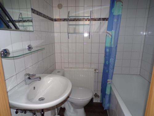 a bathroom with a sink and a toilet and a tub at Ferienwohnung am Greifswalder Bodden in Wieck