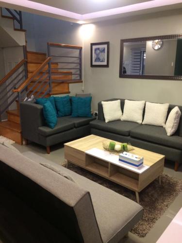 a living room with a couch and a coffee table at Hillary Timog Park Homes in Angeles