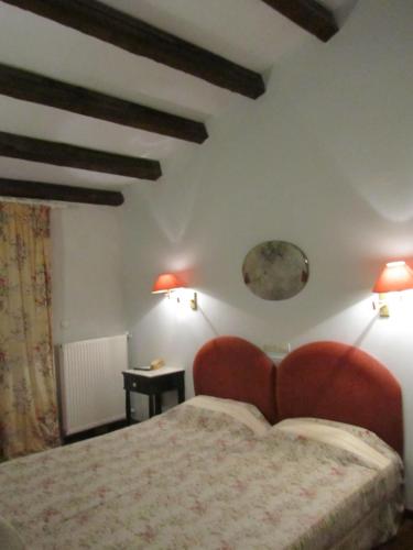 a bedroom with a bed and two lamps on the wall at Levant Hotel in Pelekas