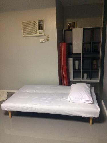 a bed with a white pillow in a room at Hillary Timog Park Homes in Angeles