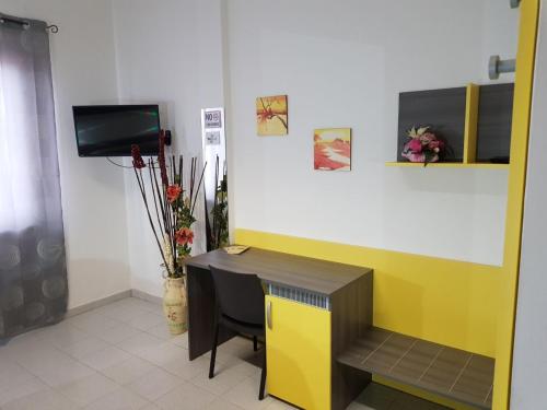 a room with a desk and a tv in a room at L Anfora in Tramatza
