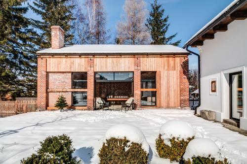 a brick house with a patio in the snow at Mezi plůtky boutique dům in Čeladná