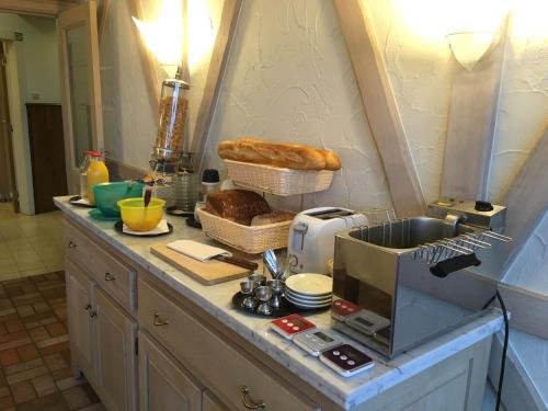 a kitchen with a counter with bread and a toaster at Auberge Saint-Martin in Orchimont
