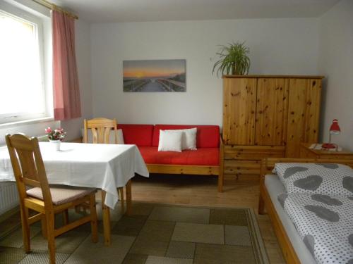 a living room with a red couch and a table at Ferienwohnungen Pilke in Oranienburg