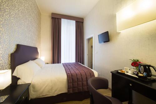 a hotel room with a bed and a desk at Hotel Montreal in Florence