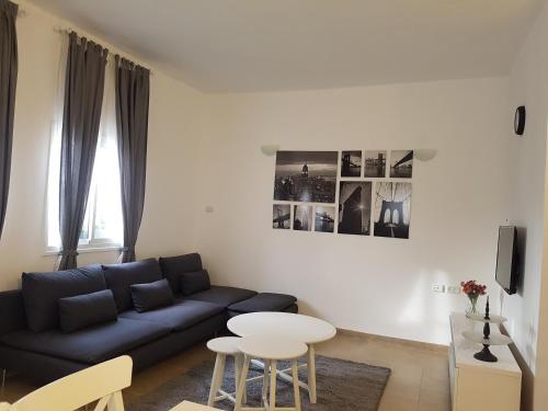 a living room with a blue couch and a table at אבני החושן- Avnei Hoshen in Nahariyya