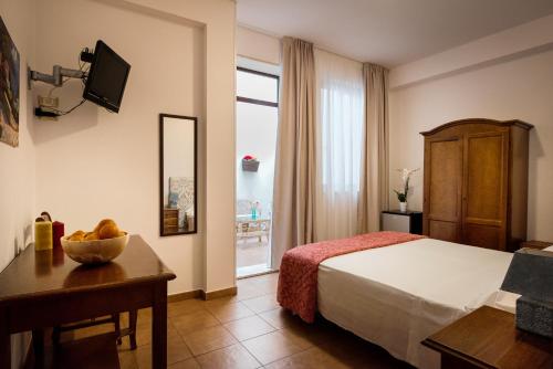 Habitación de hotel con cama, mesa y ventana en Cabrera House, en Pozzallo