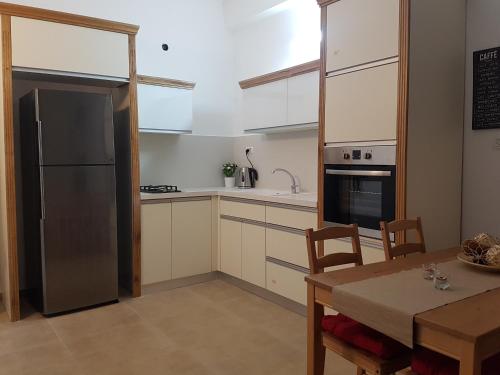 a kitchen with a table and a stainless steel refrigerator at אבני החושן- Avnei Hoshen in Nahariyya