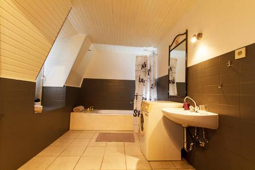 a bathroom with a sink and a bath tub at Villa im Reiterdorf in Beverstedt
