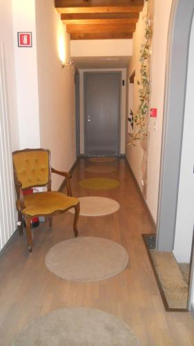 a hallway with a chair and a table and a door at Ristolocanda Grani Di Pepe in Flaibano