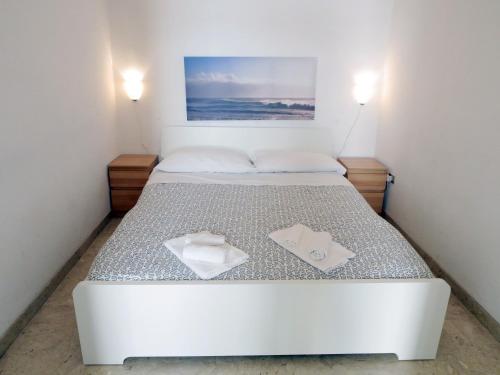 ポリニャーノ・ア・マーレにあるLa Conchiglia Domusの白いタオル2枚が備わるドミトリールームのベッド1台分です。