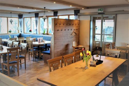 a restaurant with a wooden table and chairs and tables at Berggasthaus Kraxenberger in Brannenburg