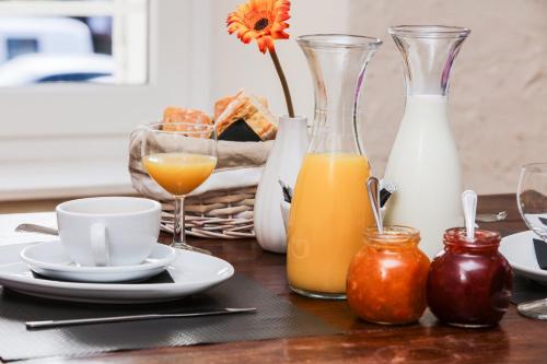 a table with glasses of orange juice and a glass of milk at Terra Gasconha in Barbaste